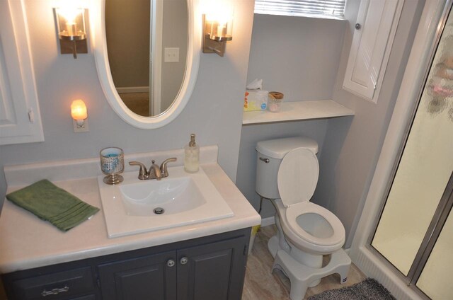 full bath featuring toilet, a shower stall, and vanity