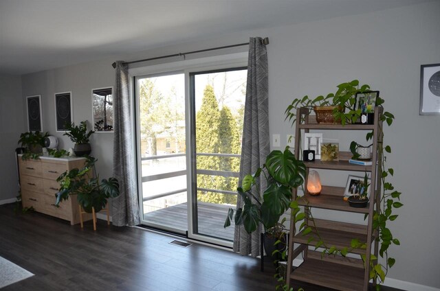 doorway with visible vents, baseboards, and wood finished floors