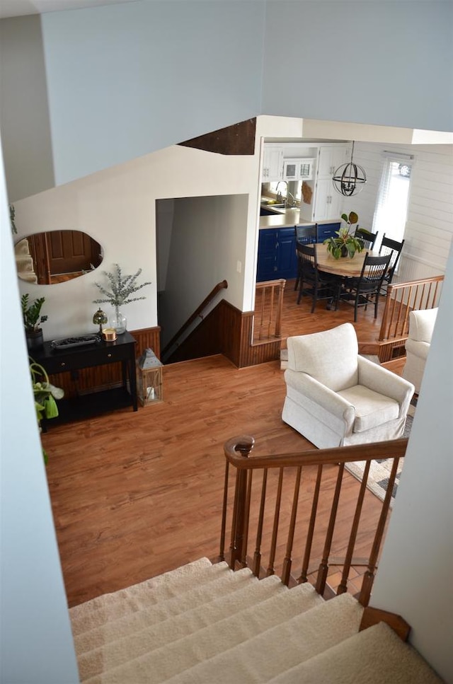 stairs with wood finished floors and a towering ceiling