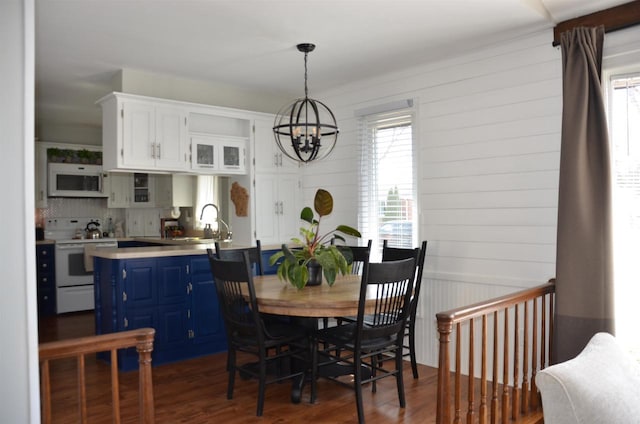 dining space featuring a wealth of natural light, dark wood-style floors, and an inviting chandelier