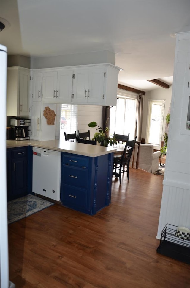 kitchen with dark wood finished floors, a peninsula, light countertops, dishwasher, and blue cabinets