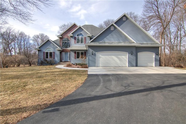 view of front of house with a front yard, an attached garage, and driveway