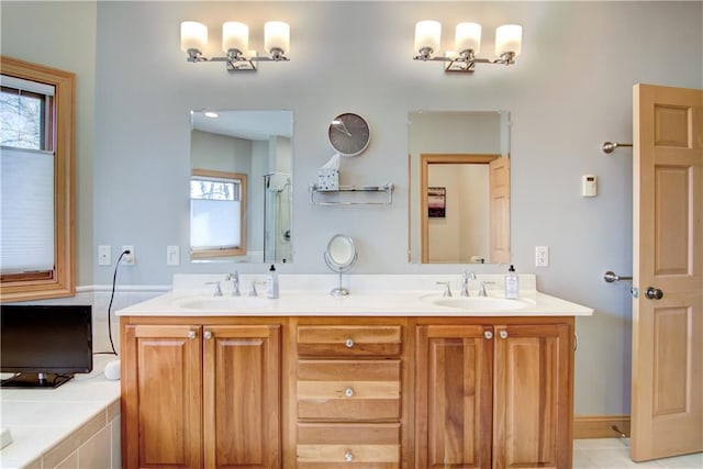 full bathroom featuring a sink, a bathtub, and double vanity