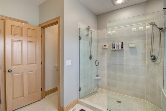 full bath with tile patterned flooring, a shower stall, and baseboards