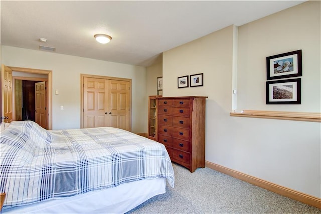 bedroom featuring visible vents, baseboards, carpet, and a closet