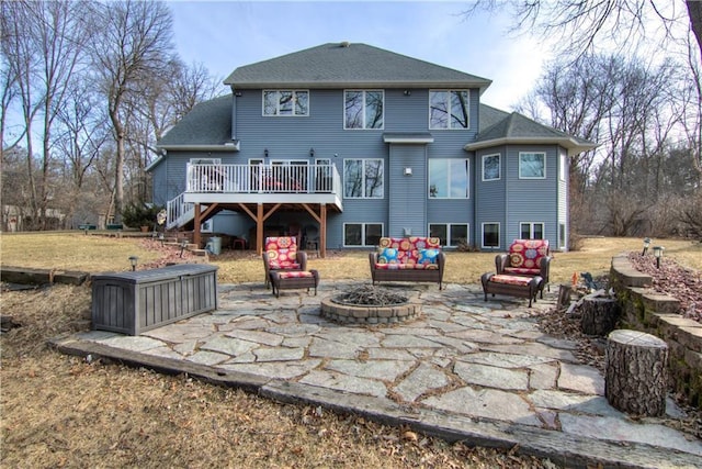 rear view of house featuring a wooden deck, stairway, a fire pit, and a patio