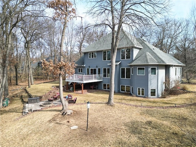 back of house featuring a deck, a yard, and roof with shingles