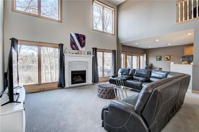 living room with recessed lighting, light colored carpet, a fireplace, and baseboards