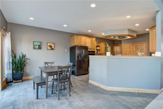 kitchen with light brown cabinetry, black fridge, recessed lighting, a peninsula, and baseboards