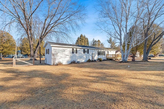 view of front facade featuring a wooden deck and a front yard