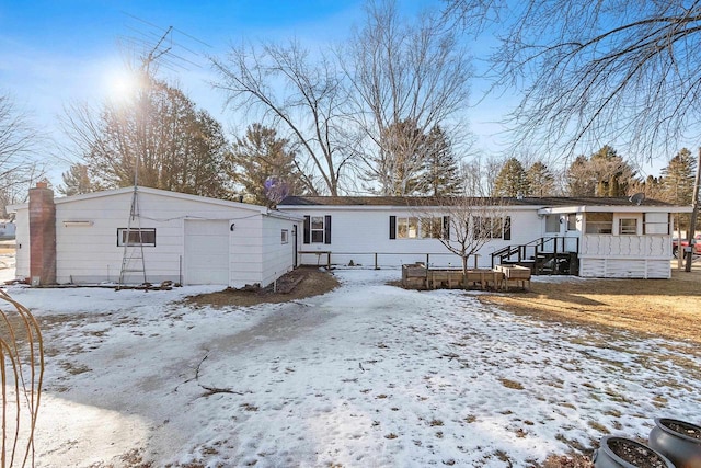 snow covered property with a garage