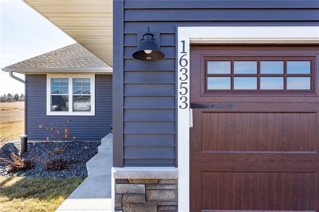 doorway to property featuring a shingled roof