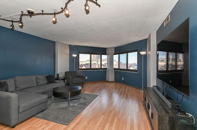 living area with wood finished floors and a textured ceiling