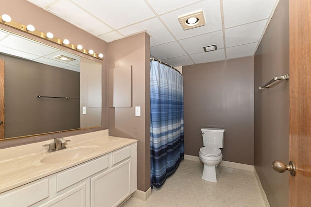 full bathroom with baseboards, toilet, tile patterned floors, vanity, and a paneled ceiling