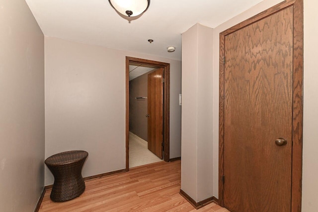 hall with baseboards and light wood-style floors