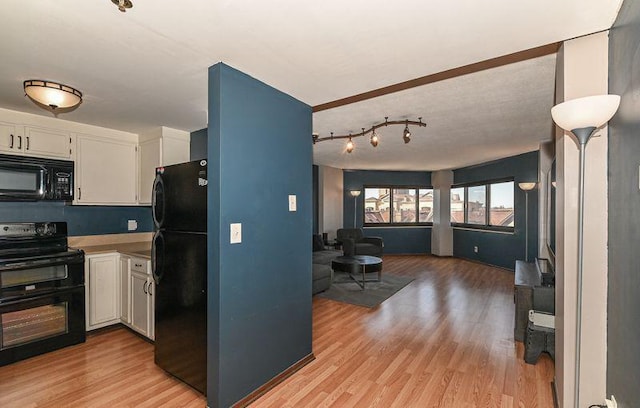 kitchen featuring open floor plan, white cabinetry, black appliances, and light wood-style floors