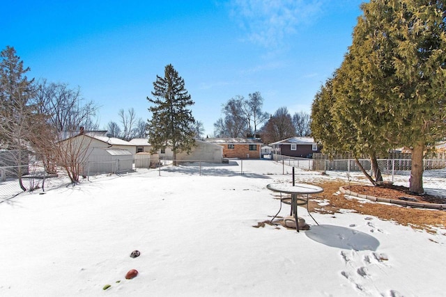 yard covered in snow featuring fence