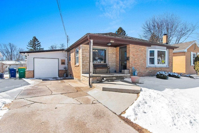 view of front of property with a chimney, concrete driveway, a garage, stone siding, and brick siding