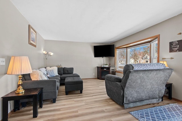 living area featuring baseboards and light wood finished floors