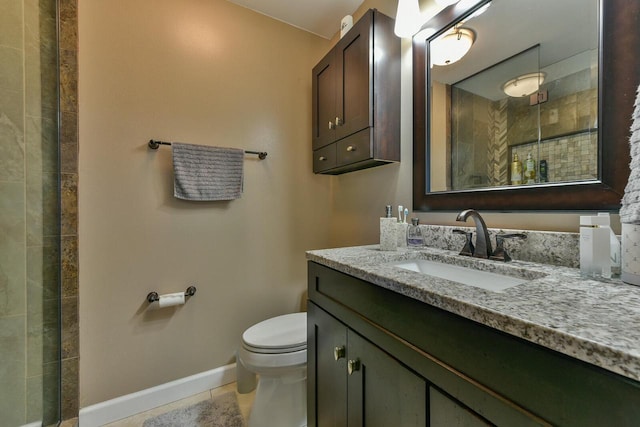 bathroom with baseboards, toilet, a tile shower, tile patterned floors, and vanity