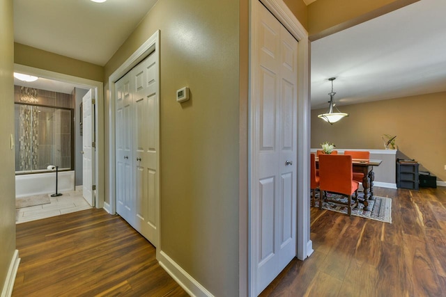 hallway featuring baseboards and wood finished floors