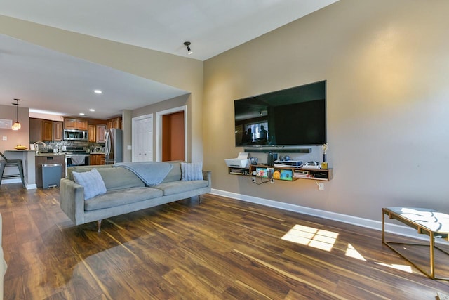 living area with recessed lighting, baseboards, and dark wood finished floors