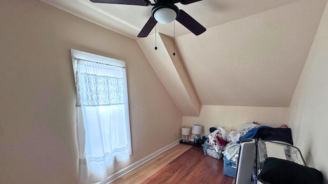 additional living space with baseboards, lofted ceiling, and wood finished floors