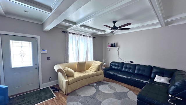 living area with wood finished floors, coffered ceiling, and a healthy amount of sunlight