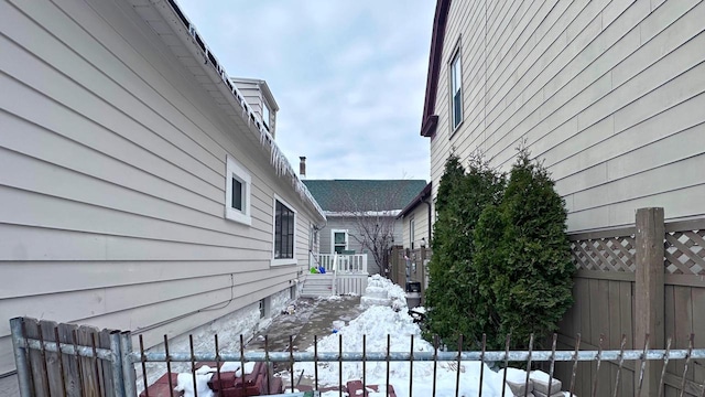 view of snow covered exterior with fence