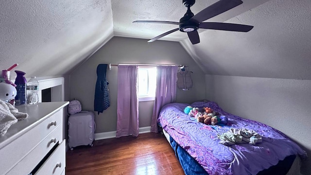 bedroom featuring lofted ceiling, a textured ceiling, and wood finished floors