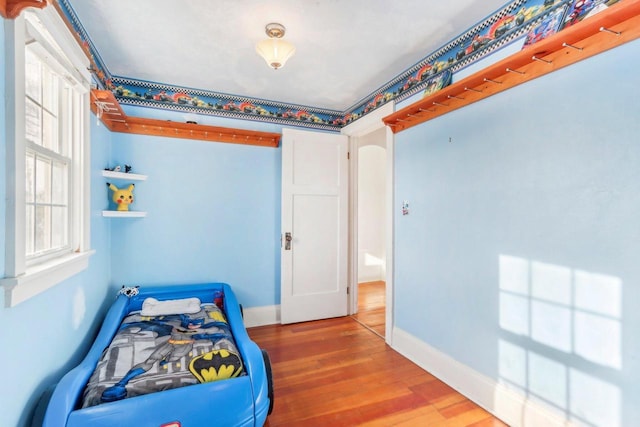 bedroom with baseboards and wood finished floors