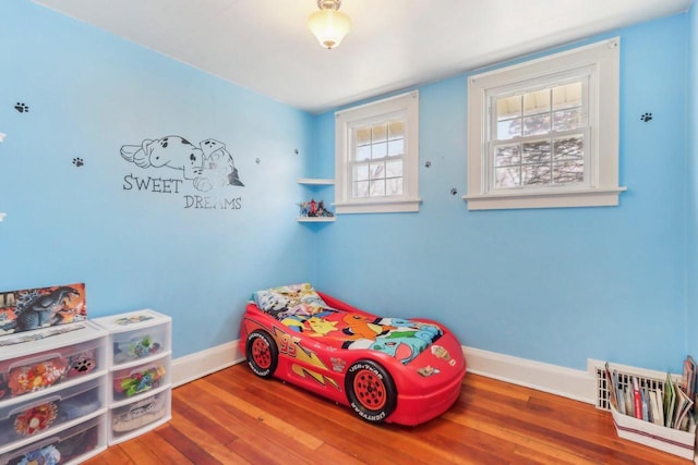 bedroom with wood finished floors and baseboards