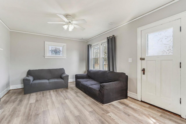 living room featuring light wood-style flooring, baseboards, crown molding, and ceiling fan