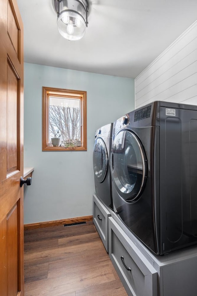 laundry room with visible vents, baseboards, laundry area, wood finished floors, and independent washer and dryer