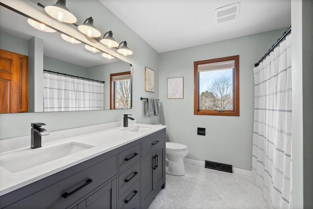 full bath with double vanity, visible vents, toilet, and a sink