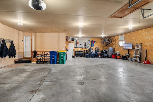 garage with a workshop area and a garage door opener