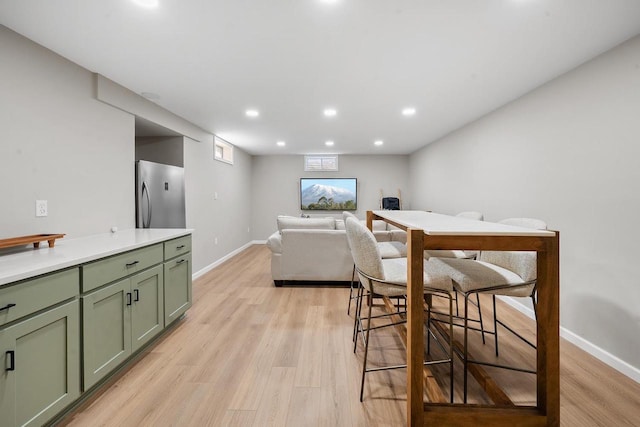 dining area featuring recessed lighting, baseboards, and light wood-type flooring