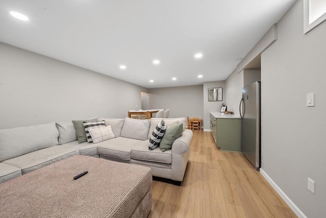 living area with recessed lighting, light wood-type flooring, and baseboards