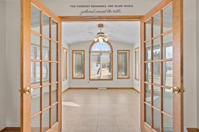 empty room with vaulted ceiling, french doors, baseboards, and visible vents