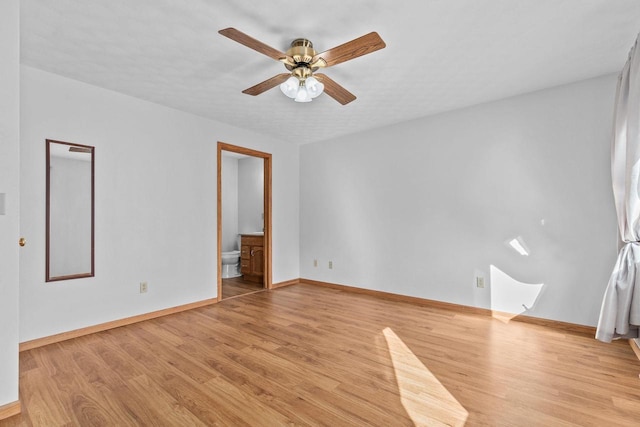 spare room featuring baseboards, light wood-style floors, and a ceiling fan