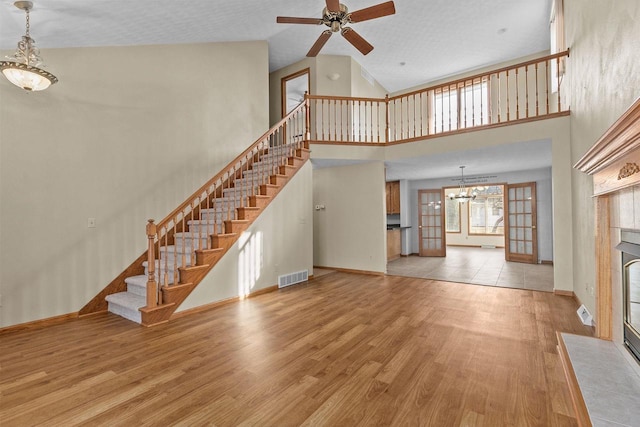 unfurnished living room with stairs, visible vents, wood finished floors, and a fireplace