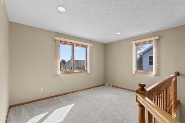 empty room featuring visible vents, baseboards, carpet floors, recessed lighting, and a textured ceiling