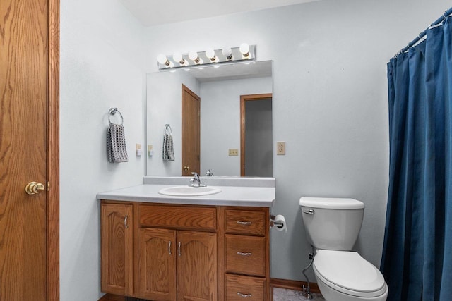 full bath featuring vanity, toilet, and baseboards