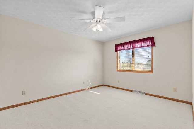 empty room featuring visible vents, baseboards, ceiling fan, and carpet flooring