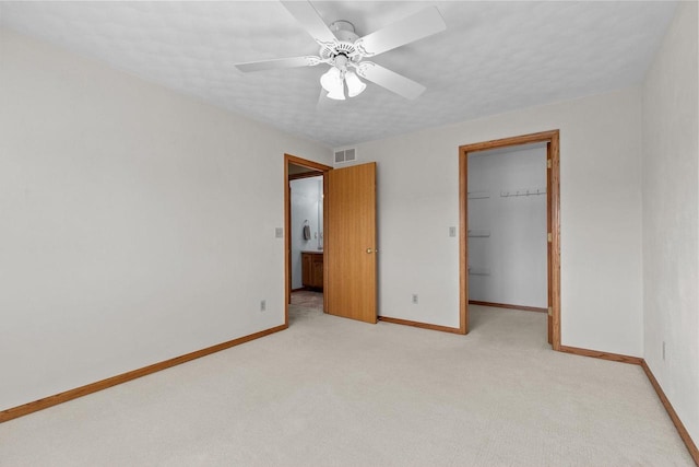 unfurnished bedroom featuring visible vents, baseboards, a closet, and a spacious closet