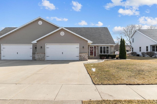 view of front of property with brick siding, a garage, a front yard, and driveway