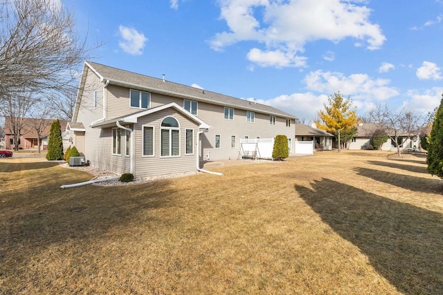 rear view of property featuring a yard and central AC