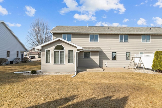 rear view of house with fence, a patio area, and a lawn