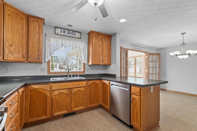 kitchen with brown cabinets, a peninsula, stainless steel appliances, and a sink