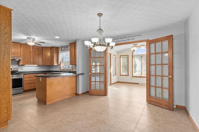 kitchen with brown cabinetry, baseboards, a peninsula, stainless steel range, and french doors